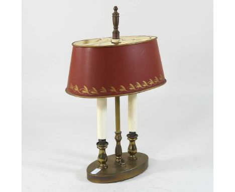 An early 20th century brass table lamp, with a red tole shade, 34cm high