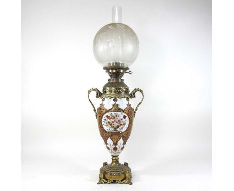 A 19th century Bohemian overlaid ruby glass oil lamp, reserved with flowers, having gilt scrolling decoration and brass scrol