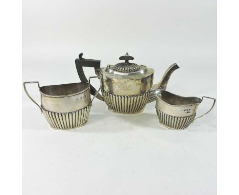 A Victorian silver three piece bachelor's tea service, with half gadrooned decoration, Birmingham 1899, 372g gross, in a fitt