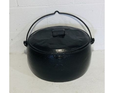 A vintage cast iron lidded cauldron
