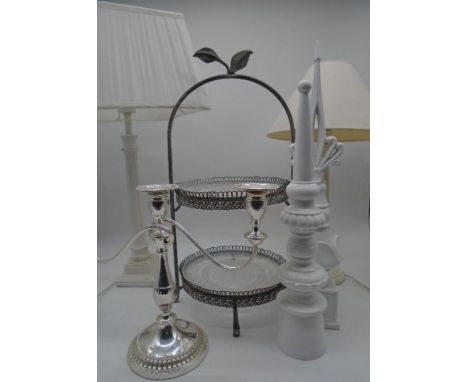 A silver plated candlestick, a cake stand, two decorated wooden finials and two classical style lamps. 