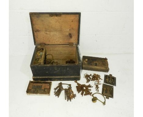 A small antique wooden trunk containing various metal door furniture, locks and keys etc.