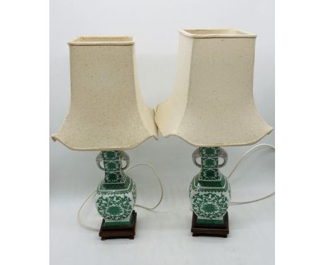 A pair of Chinese ceramic lamps with elephant head handles on wooden bases