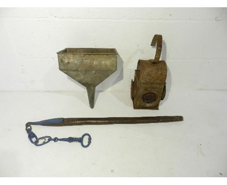 An antique bull leader along with a carriage lamp and a metal funnel