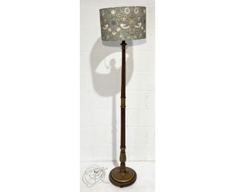 A standard lamp with gilded decoration on bun feet
