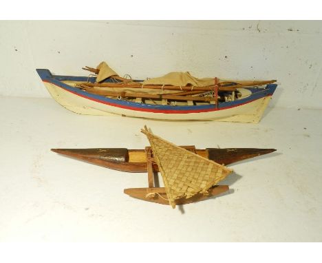 A model boat along with a tribal wooden model of an outrigger (A/F)