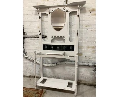 A white painted Art Nouveau style hall stand, with bevelled mirror, six coat hooks, inset tiles, open shelf and two stick sta