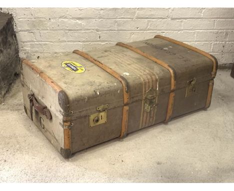 An early 20th century steamer trunk, wooden bound with leather carry handle to each end, the interior fitted with lift out tr