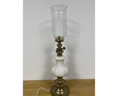 A table lamp, possibly converted from oil burning lamp, the glass shade above a ceramic body on circular base with brass fini