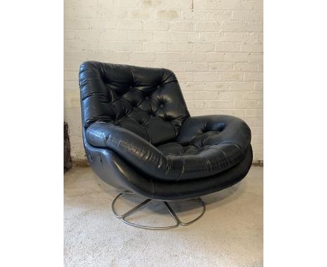 A Vintage lounge chair, circa 1970, upholstered in buttoned black faux leather, raised on a chrome swivel base, H87cm, W89cm,