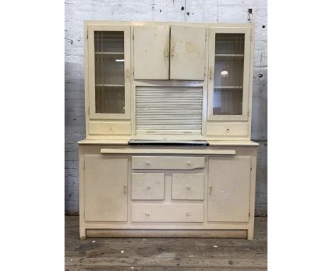 A Vintage cream painted kitchen larder unit, the top centred with a double cupboard over a tambour fronted cupboard, flanked 