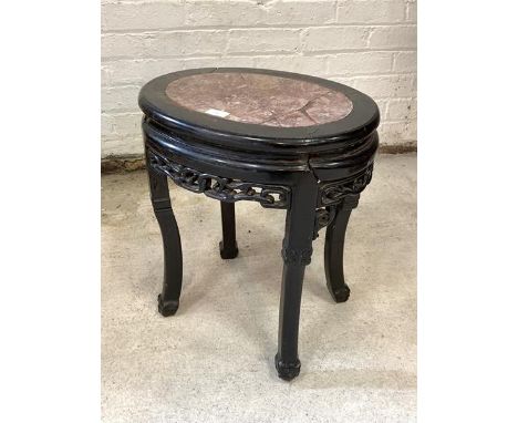 An early 20th century Chinese hardwood jardiniere stand of oval outline, the top with inset marble panel over pierce carved f