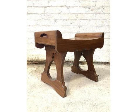 A 20th century stained teak stool, with concave top over scalloped apron, raised on pierced panel end supports, H43cm, W49cm,