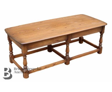 Ercol elm coffee table, turned legs on straight stretchers, approx 114 l x 49 w x41 h cms.&nbsp;