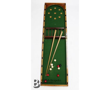 A large folding table top bagatelle, with ten balls and two cues with a green felt interior housed in a wooden box, approx. 1