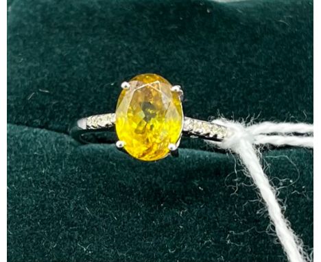 10ct white gold ladies ring set with an oval cut yellow stone off set by diamond shoulders. [Ring size R] [2.15Grams] 