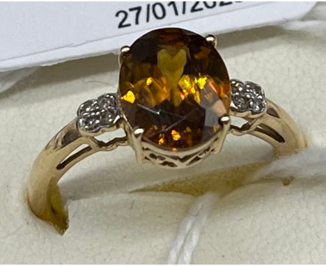10ct yellow gold ladies ring set with an Orange cut glass stone off set by diamond shoulders. [Ring size p 1/2] [2.18grams] 