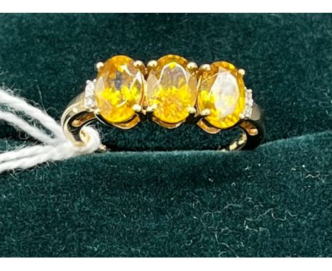 10ct yellow gold ladies ring set with three yellow stones off set by diamond shoulders. [Ring size N] [2.44Grams] 