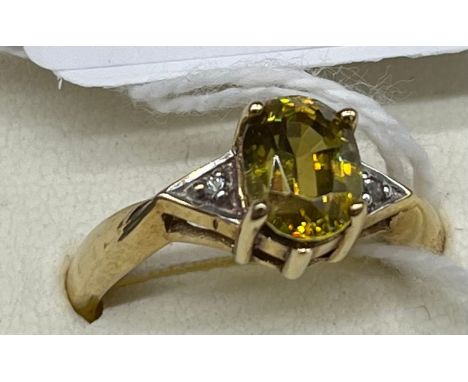 9ct yellow gold ladies ring set with a large yellow cut glass stone off set by white quartz stones to the shoulders. [Ring si