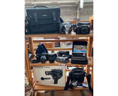 Three shelves of camera items to include Polaroid image system camera and case, Canon t50 camera with lenses, Movexoom 10 sou