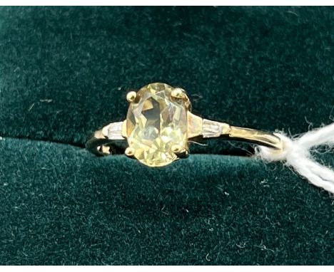 10ct yellow gold ladies ring set with a pale green topaz off set by diamond shoulders. [Ring size P] [2.03Grams] 