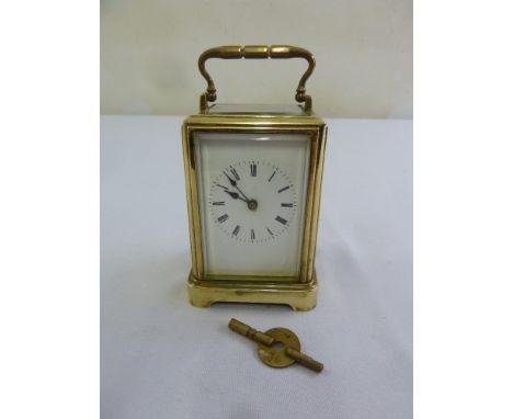 A brass carriage clock of customary form, to include key