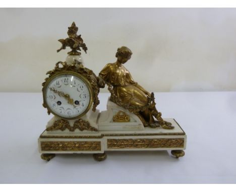 A French 19th century gilt metal and white marble mantle clock, the circular enamel dial flanked by a classical female figuri