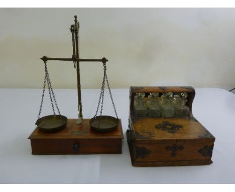 A brass balance scale and a four bottle desk drinks cabinet