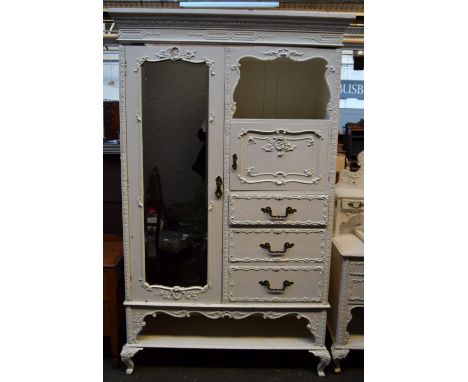 A wardrobe with mirrored door, shelf and three drawers, one cupboard door decorated with foliate scrolls