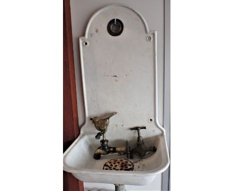 A CONTINENTAL ENAMELLED IRON WALL-MOUNTED WASH BASIN with integral splashback, drain grille, hole for tap 32cm wide, with two