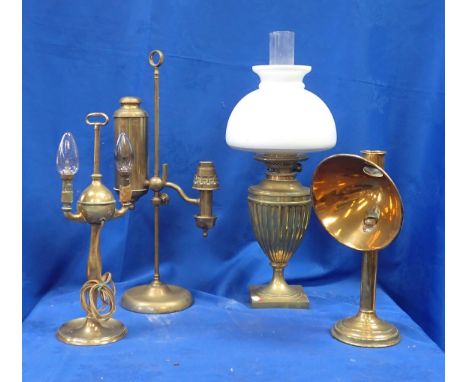 A VICTORIAN HEAVY BRASS OIL LAMP OF URN FORM with white shade, a brass student's lamp, and two other brass lamps (4)