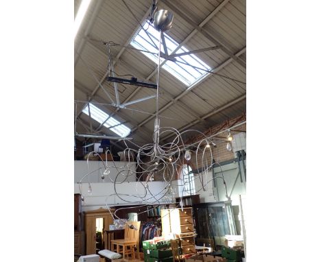 A CONTEMPORARY CHROME HANGING LIGHT of contorted wire form, with small bulbs and pear-shaped drops (untested)