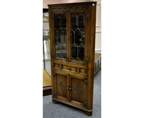 An oak floor standing corner cupboard with glazed leaded light.