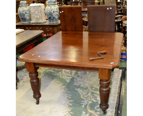 A Regency style mahogany wind out dining table, canted corners, turned and reeded legs, ceramic casters. 75cm high x 122cm wi