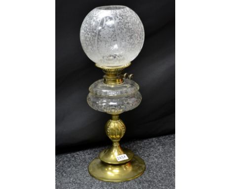 A Victorian brass oil lamp with clear glass reservoir.