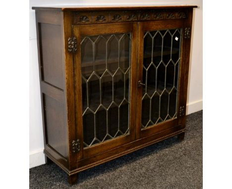 An oak bookcase with glazed leaded light.