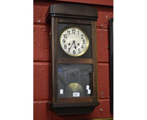 An early 20th century oak wall clock, Arabic numerals, silvered dial, twin winding holes
