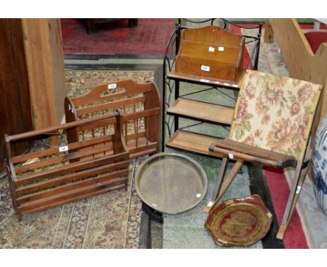 A gout stool; two wooden magazine racks; a wooden letter rack; a wrought iron and canework collapsible shelf unit; a papier-m