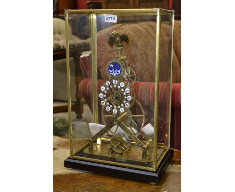 A contemporary skeleton clock with eagle finial under glass case.