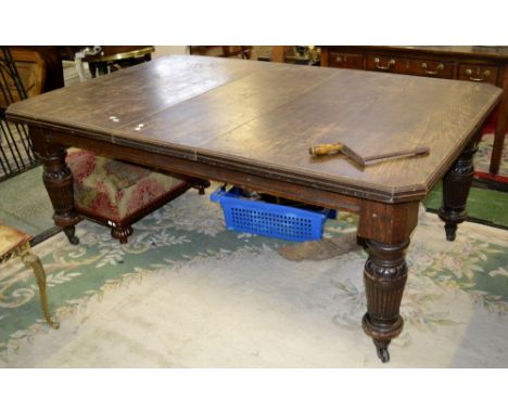 An oak wind out dining table, canted corners, turned and reeded supports, ceramic casters, circa 1830. one leaf. 75cm high x 