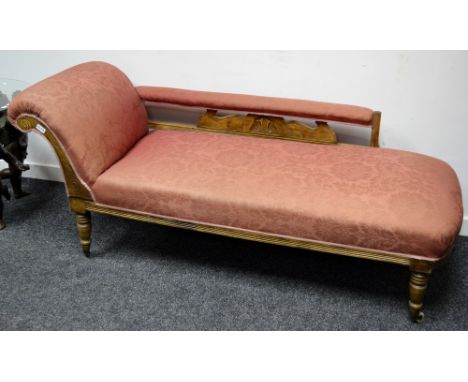 A late Victorian mahogany chaise longue, padded back rail, scrolling arm, stuffed overseat, turned legs, ceramic casters, cir