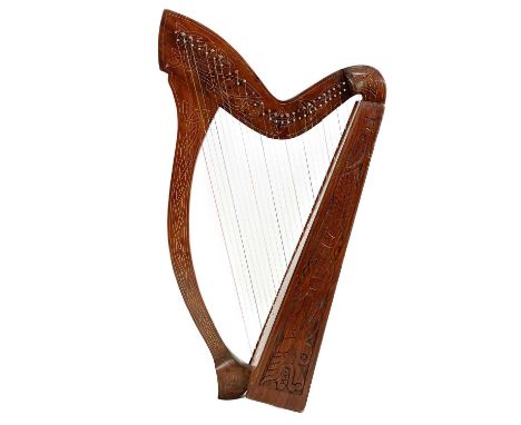 A Celtic Harp.  With twenty-seven strings and a mahogany body, the instrument is decorated with a carved dragon and a Celtic 