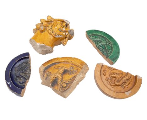 Ming Dynasty A yellow glazed fragment of a Buddhist lion roof tile figure and four glazed roundel fragments (blue, green, and