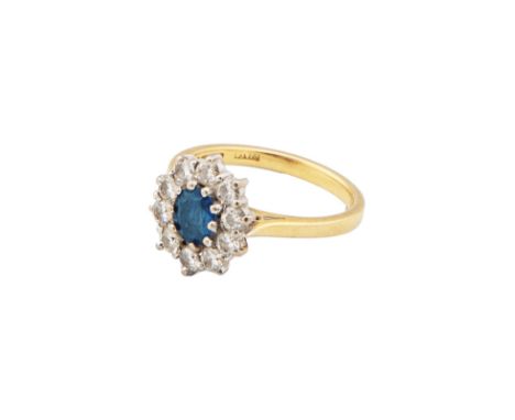 A Sapphire and diamond cluster ring The oval mixed cut sapphire within a surround of ten small brilliant cut diamonds Mounted