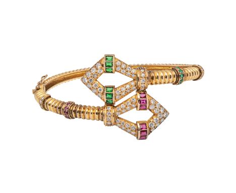 Circa 1980 A diamond, emerald, and ruby, yellow metal bangle ofÂ&nbsp;fluted design  Weight: Approximately 16 grams