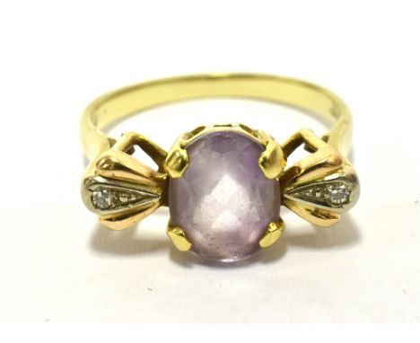 VINAGE GOLD GEM SET DRESS RNG the ring set with a pale lilac gemstone and flanked each side with a diamond accent, the shank 