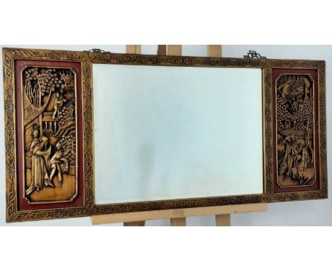 CHINESE GILTWOOD STYLE WALL MIRROR, the mirror with bevelled glass and flanked by two panels decorated in relief depicting fi