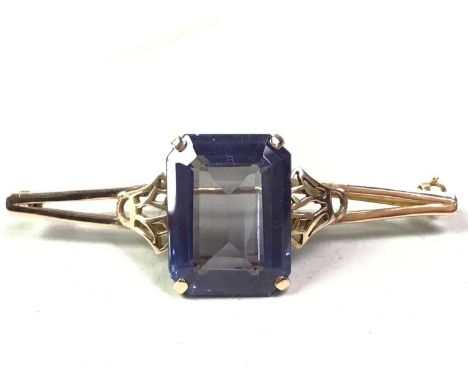 GOLD BAR BROOCH, LATE 19TH / EARLY 20TH CENTURY set with a large cushion cut purple stone, marks indistinct but most likely n