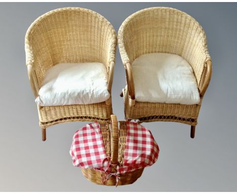 A pair of wicker armchairs together with a hamper.