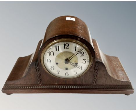 An Art Deco oak cased mantel clock with silvered dial, width 49 cm.